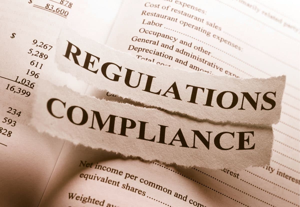 Torn newspaper headlines reading Regulations and Compliance over financial documents